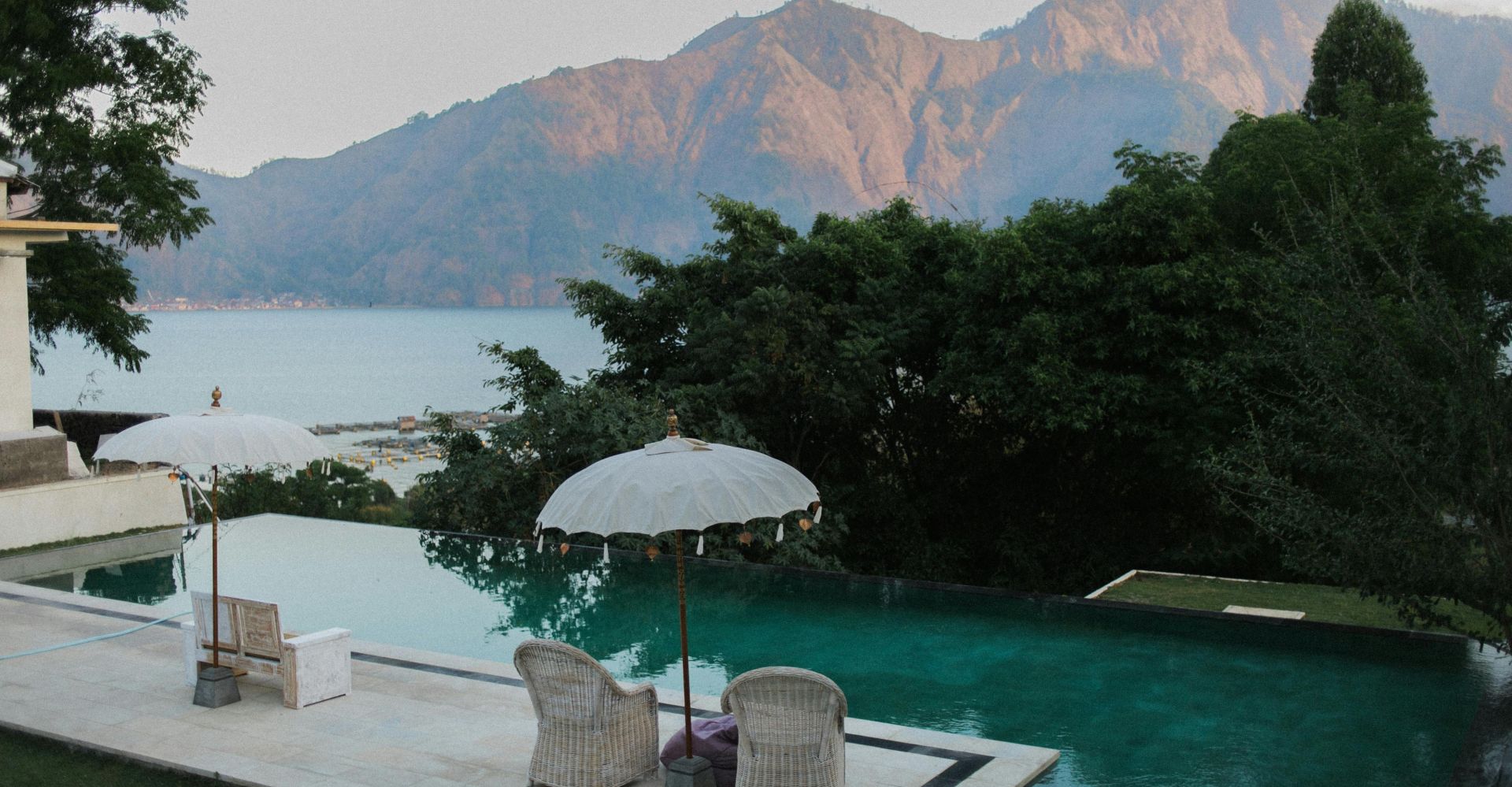 Relax by a serene infinity pool overlooking mountains and the ocean.