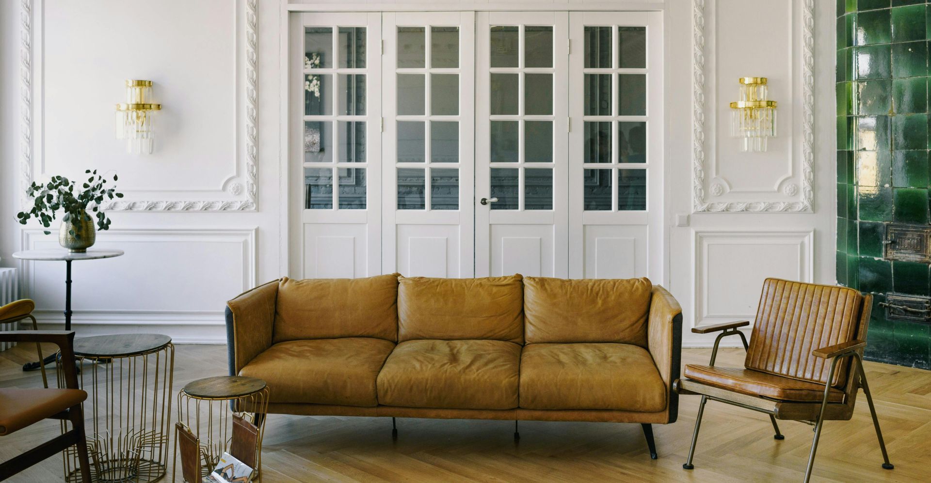 Bright living room featuring leather furniture, decorative white walls, and green tiled accent.