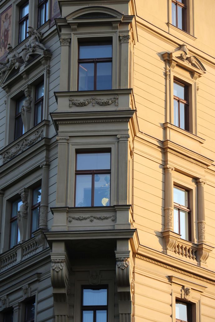 Detailed view of an ornate historical building facade with classic architectural detailing at sunset.